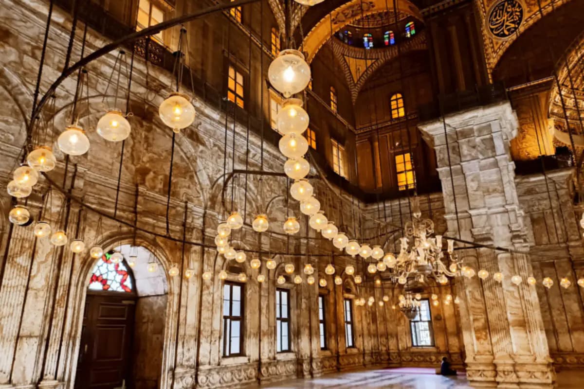 Rows of hanging glass lamps and a chandelier in the alabaster prayer hall of the Mosque of Muhammad Ali