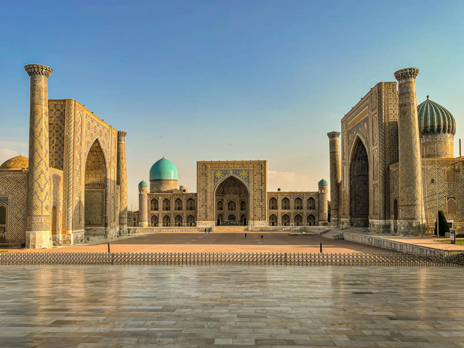 The tiled madrasas of the Registan in Samarkand glowing in golden evening light